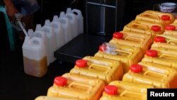 Seorang petugas mengisi jerigen dengan minyak goreng di sebuah stasiun distribusi di Jakarta, Indonesia, 20 Mei 2022. (REUTERS/Willy Kurniawan)