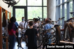 Students and volunteer teachers fix up bicycles at Phoenix Bikes in Arlington, Virginia. (Dan Novak/VOA)