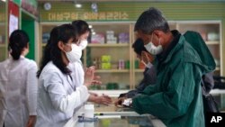 16일 북한 평양 대성구역 의약품관리소 직원들이 주민들에게 약을 처방하고 있다.