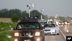 FILE - In this May 19, 2010 file photo taken near Kingfisher, Okla., storm chasers and spectator vehicles clog the road and shoulder of Highway 81.