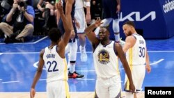 L'attaquant des Golden State Warriors Andrew Wiggins (22) et l'attaquant des Golden State Warriors Draymond Green (23) et le gardien des Golden State Warriors Stephen Curry (30) pendant la deuxième mi-temps contre les Dallas Mavericks le 22 mai 2022 à Dallas, Texas.