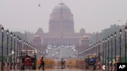 A construction worker walks across a road during a heat wave, in New Delhi, May 2, 2022. (AP Photo/Manish Swarup)