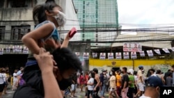 People line up to vote at a polling station Monday, May 9, 2022, in Manila, Philippines. 