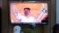 People watch a TV screen showing a news program reporting about North Korea's missile launch with file footage of North Korean leader Kim Jong Un at a train station in Seoul, South Korea, May 12, 2022.