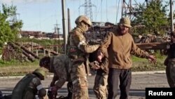 러시아 국방부가 지난 17일 공개한 영상 속 장면. 우크라이나 남동부 마리우폴 시내에서 친러시아 병력이 우크라이나군 투항 장병들의 몸수색을 진행하는 모습이라고 설명했다.