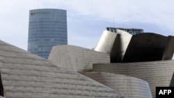 The Iberdrola Tower building is seen behind the Guggenheim Bilbao museum, on Feb. 21, 2012, in the Northern Spanish Basque city of Bilbao. 