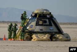 In this handout image, courtesy of NASA, Boeing and NASA teams work around Boeing's CST-100 Starliner spacecraft after it landed at White Sands Missile Rangs Space Harbor, May 25, 2022, in New Mexico. (Photo by Bill INGALLS / NASA / AFP)