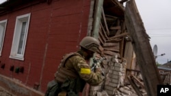 A Ukrainian serviceman patrols during a reconnaissance mission in a recently retaken village on the outskirts of Kharkiv, east Ukraine, May 14, 2022.