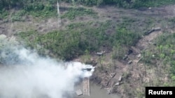 Smoke rises from what appears to be a makeshift bridge across the Siverskyi Donets River, eastern Ukraine, in this handout image uploaded on May 12, 2022. (Ukrainian Airborne Forces Command/Handout via REUTERS)