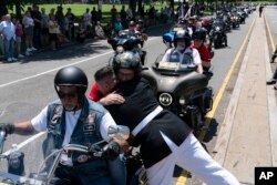 U.S. Marine Corps Staff Sgt. Tim Chambers hugs a participant in the "Rolling to Remember" motorcycle rally on May 29, 2022. Organizers staged the Washington-area ride to spotlight issues facing veterans, demand action for those missing, and raise awareness of the prevalence of suicide among veterans.