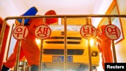 지난 5월 북한 평양에서 방역 요원들이 자동차를 소독하고 있다. (자료사진)