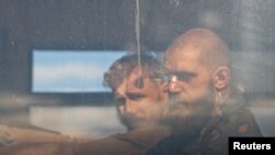Pripadnici ukrajinskih snaga koji su se predali nakon više nedjelja istrajavanja u željezari Azovstal, snimljeni dok sjede u autobusu koji ih odvozi na teritoriju koju drže proruski militanti, u Mariupolju, Ukrajina, 17, maja 2022.