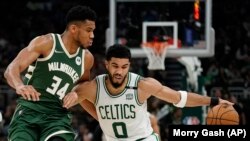 Jayson Tatum, des Boston Celtics, tente d'échapper à Giannis Antetokounmpo, des Milwaukee Bucks, lors du sixième match des demi-finales de la Conférence de l'Est, vendredi 13 mai 2022 