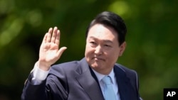 FILE -South Korea's President Yoon Suk Yeol waves from a car after his Inauguration outside the National Assembly in Seoul, May 10, 2022.