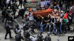 Israeli police confront mourners as they carry the casket of slain Al Jazeera veteran journalist Shireen Abu Akleh during her funeral in east Jerusalem.