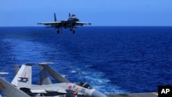 Dalam foto yang dirilis 31 Desember 2021 oleh Kantor Berita Xinhua, foto tak bertanggal menunjukkan jet tempur J-15 berbasis kapal induk bersiap untuk mendarat di kapal induk Liaoning milik angkatan laut China dalam latihan tempur di laut terbuka. (Hu Shanmin/Xinhua via AP)