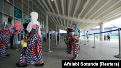 Des voyageurs dans l'aile domestique de l'aéroport international Nnamdi Azikiwe à Abuja, au Nigeria, le 8 juillet 2020. 