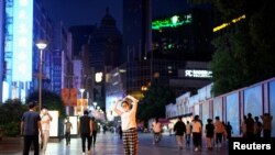 31일 중국 상하이 시내에서 마스크를 쓴 주민이 두 팔을 들어 하트 표시를 만들고 있다. 