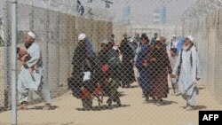 Warga Afghanistan yang berusaha melarikan diri dari kekuasaan Taliban tampak berjalan melalui koridor berpagar untuk memasuki wilayah Pakistan di perbatasan Chaman, 25 Agustus 2021 (foto: dok). 