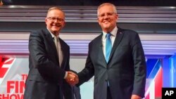 Australian Prime Minister Scott Morrison, right, and Australian opposition leader Anthony Albanese shake hands ahead of the leaders' debate in Sydney, on May 11, 2022.