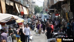 Sejumlah warga Iran tampak berjalan di sebuah pasar di Teheran, Iran, pada 1 Mei 2022. (Foto: WANA via Reuters/Majid Asgaripour)