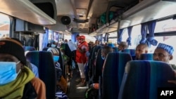FILE - A Red Cross worker takes roll call in one of the many buses planned for the return home of Central African Republic refugees in Gado, Cameroon, Dec. 2, 2020.