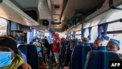 A Red Cross worker takes roll call in one of the many buses planned for the return home of Central African Republic refugees in Gado, Cameroon, Dec. 2, 2020.