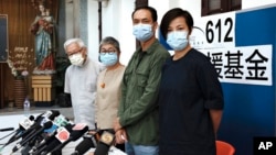 FILE - From left, retired archbishop of Hong Kong Cardinal Joseph Zen, barrister Margaret Ng, professor Hui Po-keung and singer Denise Ho attend a press conference to announce the closure of the 612 Humanitarian Relief Fund, in Hong Kong, Aug.18, 2021.