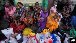 Women wait near an empty fuel station hoping to buy kerosene for cooking, in Colombo, Sri Lanka, May 26, 2022.