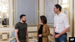 In this handout photo provided by the Ukrainian Presidential Press Office, Ukrainian President Volodymyr Zelenskyy welcomes German Foreign Minister Annalena Baerbock and Dutch Foreign Minister Wopke Hoekstra in Kyiv, Ukraine, May 10, 2022.