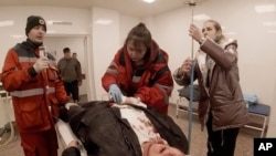 Emergency personnel work on an injured person with Yuliia Paievska, known as Taira, in Mariupol, Ukraine, on March 6, 2022.