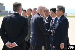 조 바이든(가운데) 미국 대통령이 22일 한국 방문을 마치고 일본으로 출발하기에 앞서 오산 공군기지에 배웅나온 박진 한국 외교부 장관과 악수하고 있다.