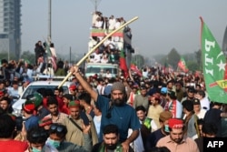 26일 파키스탄 수도 이슬라마바드에서 임란 칸 전 총리 지지자들이 현 정부 퇴진과 조기 총선을 요구하며 행진하고 있다. 가운데 보이는 차량에 칸 전 총리가 탑승했다.