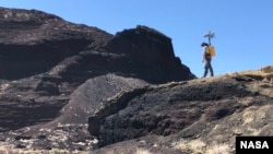 NASA scientist Michael Zanetti explores the Cinder cone in Potrillo volcanic field in New Mexico in late 2021. Zanetti was testing a working model of NASA’s KNaCK device, a mobile LiDAR scanner now in development. (Photo Credits: NASA/Michael Zanetti)
