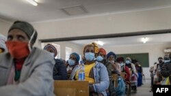 Une femme écoute lors d'une réunion communautaire pour aborder les problèmes de sécurité dans le village de Zingqolweni le 16 mai 2022.