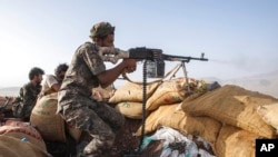 Seorang tentara Yaman menembakkan senjatanya ke pemberontak Houthi di garis depan Kassara dekat Marib, Yaman, 20 Juni 2021. (Foto: AP)