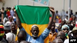 FILE - A supporter of the junta in Mali holds up the national flag during a rally in Bamako on May 13, 2022. Families of opposition politicians who were arrested by the junta said on June 26, 2024, that they have been moved to prisons.