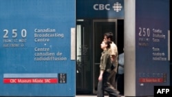 FILE - Pedestrians walk in front of the Canadian Broadcasting Corporation (CBC) building in downtown Toronto, Canada, June 7, 2006. 