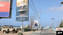 African Union peacekeepers stand next to election banners of presidential candidates along a street in Mogadishu, Somalia, May 13, 2022.
