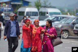 Relatives of passengers of the Tara Air turboprop Twin Otter plane that went missing wail outside the airport in Pokhara, Nepal, Sunday, May 29, 2022. The wreckage of the plane carrying 22 people that disappeared in Nepal's mountains was found Monday scat