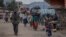 FILE - People attempt to cross the Democratic Republic of Congo and Ugandan border with their belongings to seek refuge after clashes between the Congolese army and the M23, in Bunagana, 100 kilometers from the city of Goma in eastern DRC, on April 2, 202