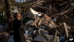Anna Shevchenko, 35, reacts next to her house in Irpin, near Kyiv, on Tuesday, May 3, 2022. (AP Photo/Emilio Morenatti)