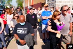 People gather outside the scene of a shooting at a supermarket in Buffalo, N.Y., May 15, 2022.