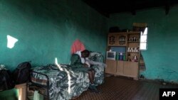 La fille de Nontukunina Mbenyana, dont le fils a été la première victime d'une vague de meurtres qui a touché le village, joue avec son téléphone dans son lit dans sa maison du village de Zingqolweni le 16 mai 2022.