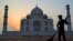 A worker sweeps the ground at the Taj Mahal at sunrise in Agra on May 12, 2022. 