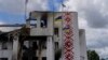 Ukrainian flags flutter outside a destroyed cultural center in Derhachi, eastern Ukraine, May 15, 2022. A Russian airstrike destroyed the venue on May 12.
