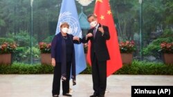 FILE - In this photo released by Xinhua News Agency, Chinese Foreign Minister Wang Yi, right, poses for photo with the United Nations High Commissioner for Human Rights Michelle Bachelet in Guangzhou, in southern China's Guangdong province, May 23, 2022.