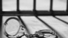 Handcuff and prison bars