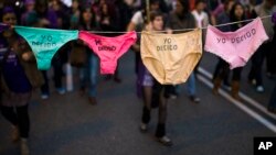 راهپیمایی زنان در حالی که لباس زیر حمل می‌کنند که روی آن نوشته شده است: «من تصمیم می‌گیرم» در جریان اعتراض به طرح دولت اسپانیا برای اعمال محدودیت‌های عمده در مورد سقط جنین و مبارزه برای حقوق زنان در روز جهانی زن در مادرید، اسپانیا - مارس ۲۰۱۴