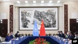FILE - In this photo released by Xinhua News Agency, Chinese Foreign Minister Wang Yi, second right, meets with U.N. High Commissioner for Human Rights Michelle Bachelet, left, in Guangzhou, Guangdong province, China, May 23, 2022.